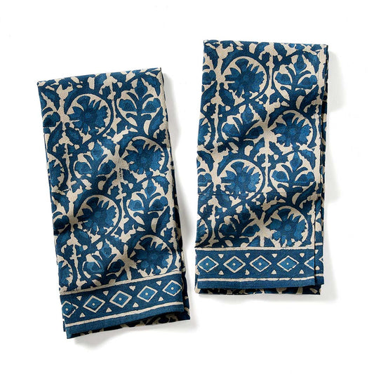 Two blue and white patterned towels on a white background