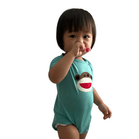 Baby wearing light green onesie with Hand-Appliquéd Batik Happy Monkey - Forai