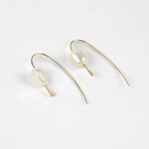 pair of 14 karat gold filled threader earrings with genuine freshwater pearls on a white background pair of 14 karat gold filled threader earrings with genuine freshwater pearls on a white background