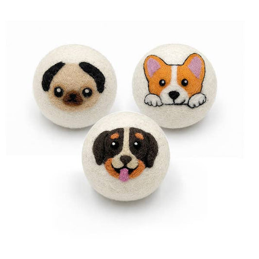 felted wool dryer ball with a dog face design on a white background
