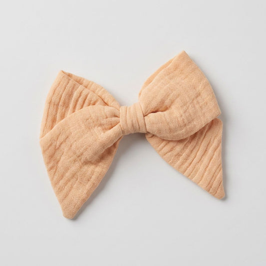 a peach hairbow made of double cotton guaze on a white background