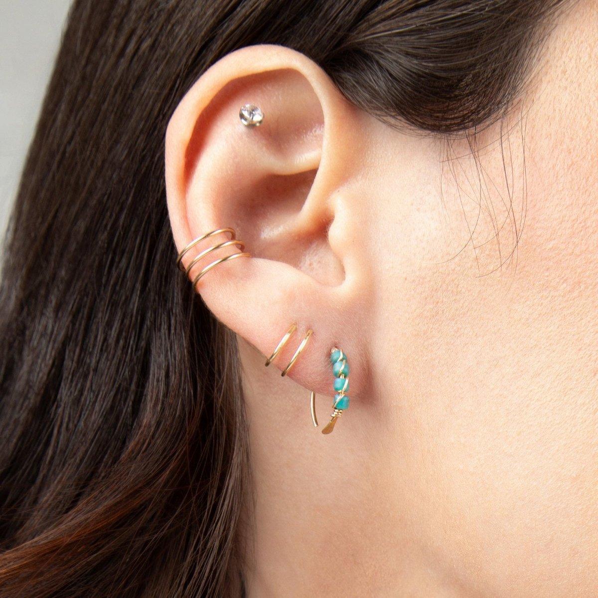 Closeup of woman wearing Journey of Hope Ear Cuff and Huggie Earrings   in 14k gold filled paired with Moab Western Turquoise Beaded Earrings.