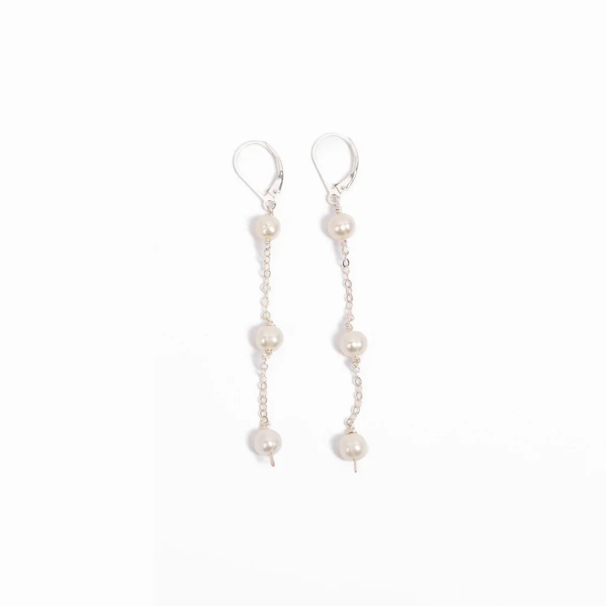 Pair of elegant freshwater pearl triple drop leverback earrings in sterling silver on a white background