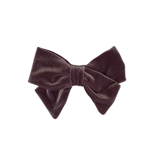 Woman with long hair is seen from the back, wearing a rose gold velvet hair bow barrette in their hair.