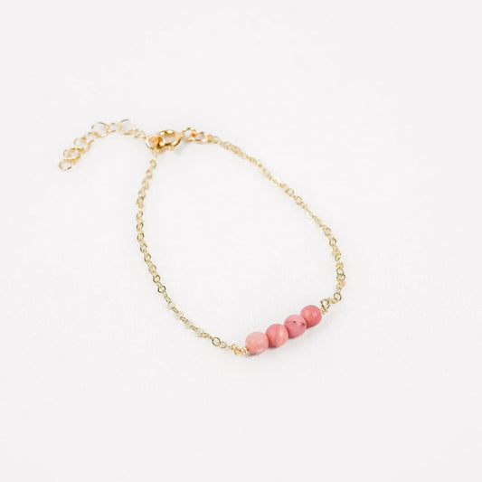 gold chain bracelet with four pink rhodonite beads in the center