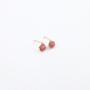 pair of gold stud earrings with pink beads in the center on a white background pair of gold stud earrings with pink beads in the center on a white background