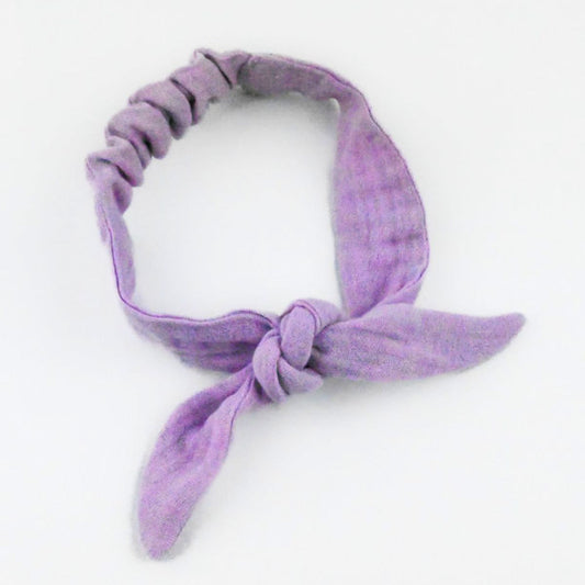Purple knotted headband on a white background