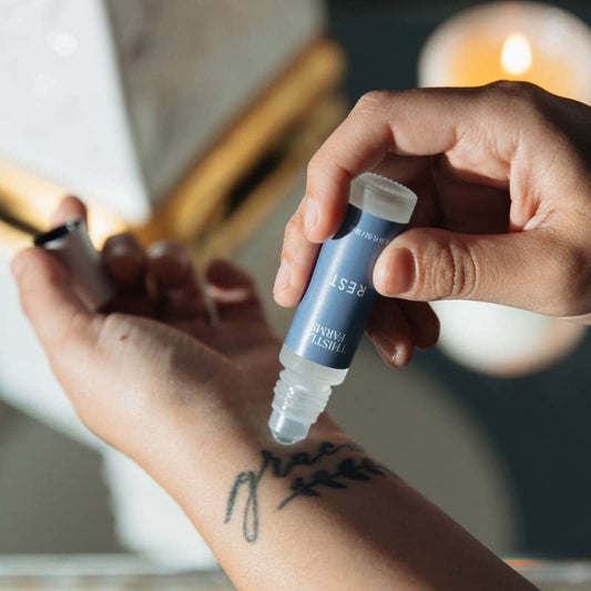 Thistle Farms Rest essential oil roll-on with Bergamot, Chamomile, and Neroli.