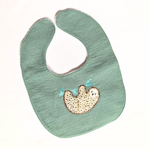 Green baby bib with a sloth design on a white background Green baby bib with a sloth design on a white background