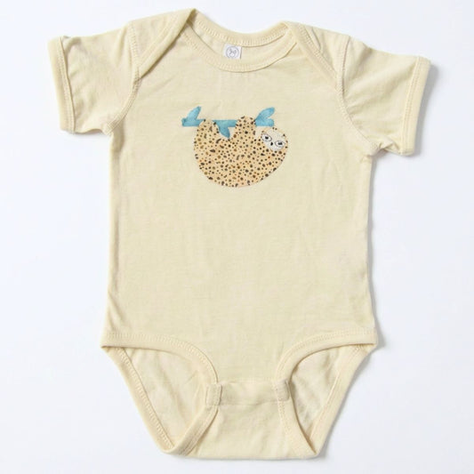Beige baby onesie with a sloth design on a white background