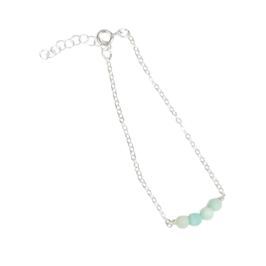 Woman in navy pleated shirt wearing the minimalist Jordan Amazonite Bracelet in sterling silver.