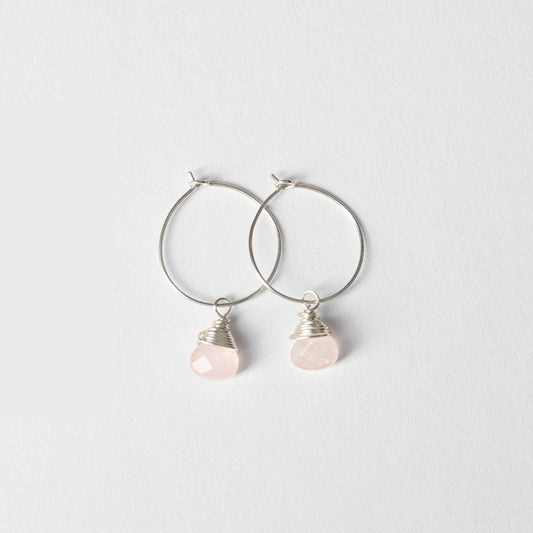A woman wearing Mini-hoop Rose Quartz Charm Earrings, showcasing her right ear.