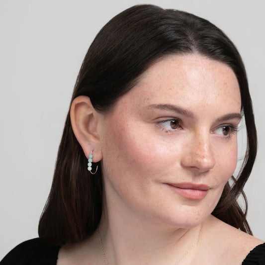 Woman in a black top wearing Amazonite J Hoop Earrings in Sterling Silver. Minimalist.