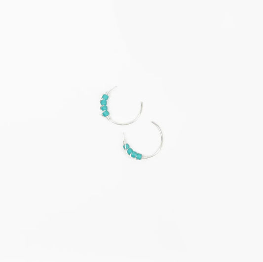 A close-up image of a woman's ear wearing Moab Western Beaded Threader Earrings in sterling silver. Hoop earring with turquoise beads.
