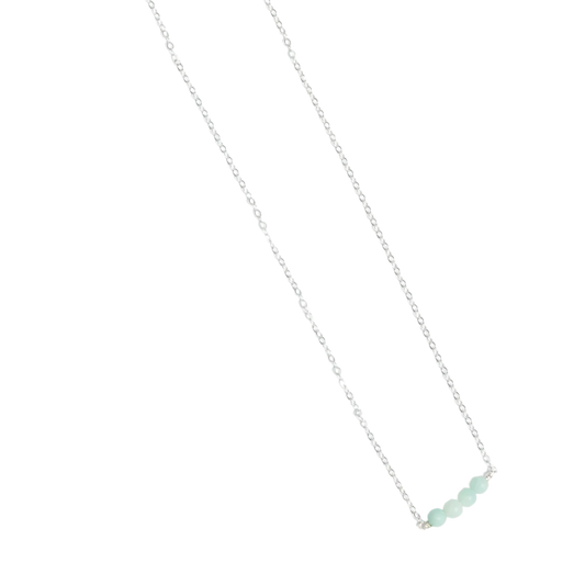 Woman in a navy pleated shirt wearing a Jordan Amazonite bracelet in sterling silver on her wrist,.