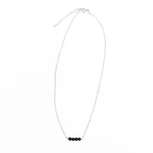 Sterling silver minimalist necklace with black onyx beads on a white background Sterling silver minimalist necklace with black onyx beads on a white background