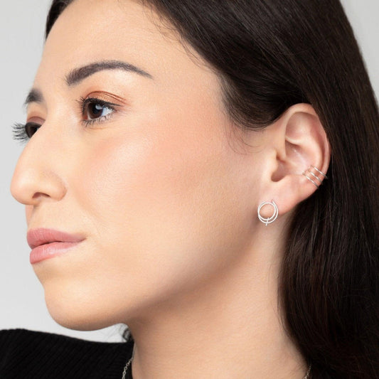 A young woman wearing the Zomi Open Circle Earrings in Sterling Silver, featuring a double circle and mini-threader design.