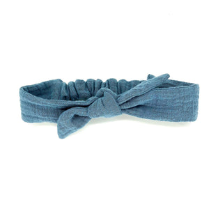 A handmade and adjustable dusty blue double cotton gauze tie headband for kids on a white background A handmade and adjustable dusty blue double cotton gauze tie headband for kids on a white background