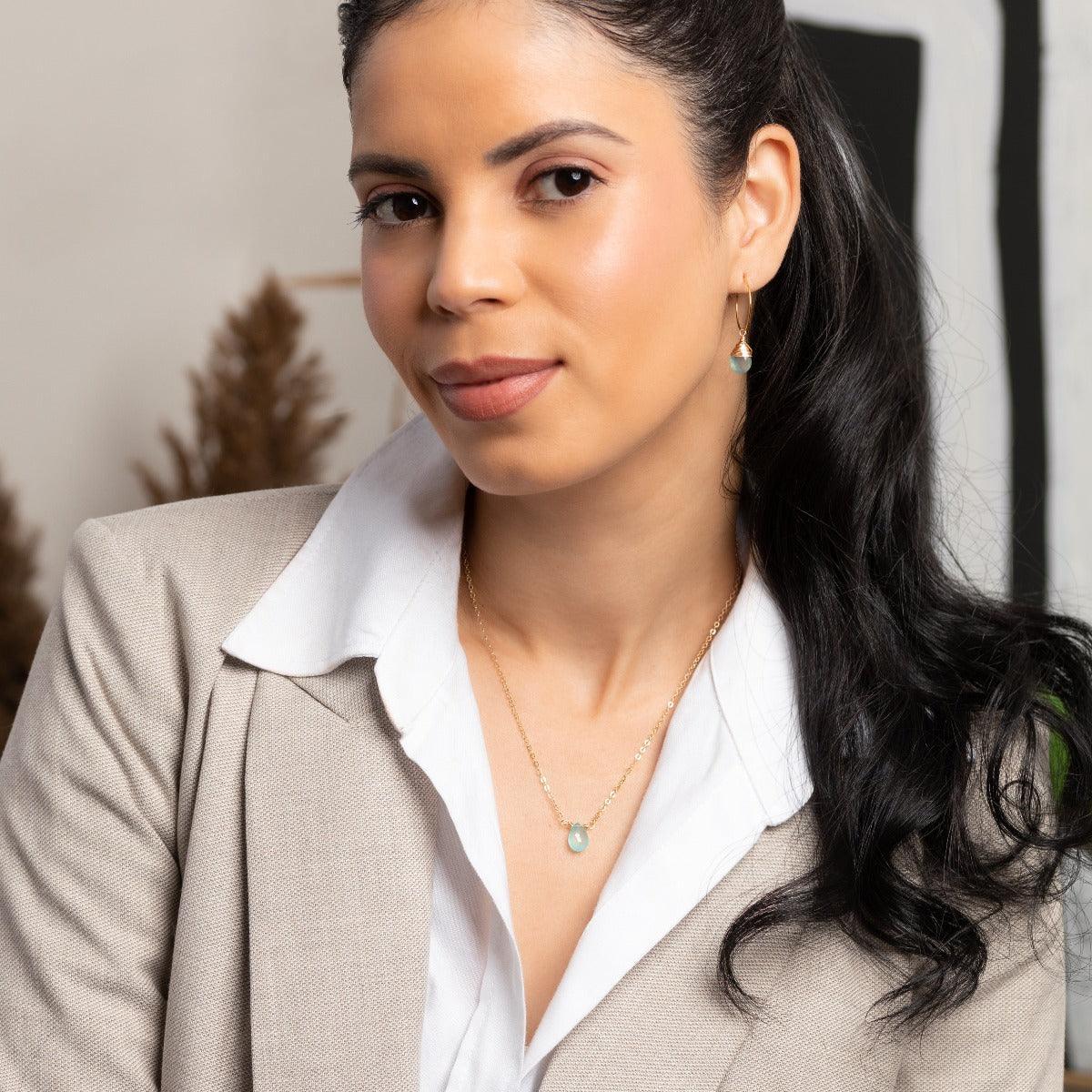 Woman in beige blazer wearing classic Aqua Chalcedony Hoop Earrings and Necklace in 14k Gold Filled