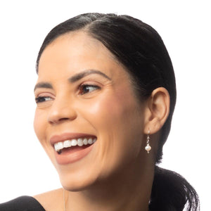 A woman wearing Leeda Freshwater Pearl Earrings in Sterling Silver, featuring a single pearl drop and hammered detailing. A woman wearing Leeda Freshwater Pearl Earrings in Sterling Silver, featuring a single pearl drop and hammered detailing.