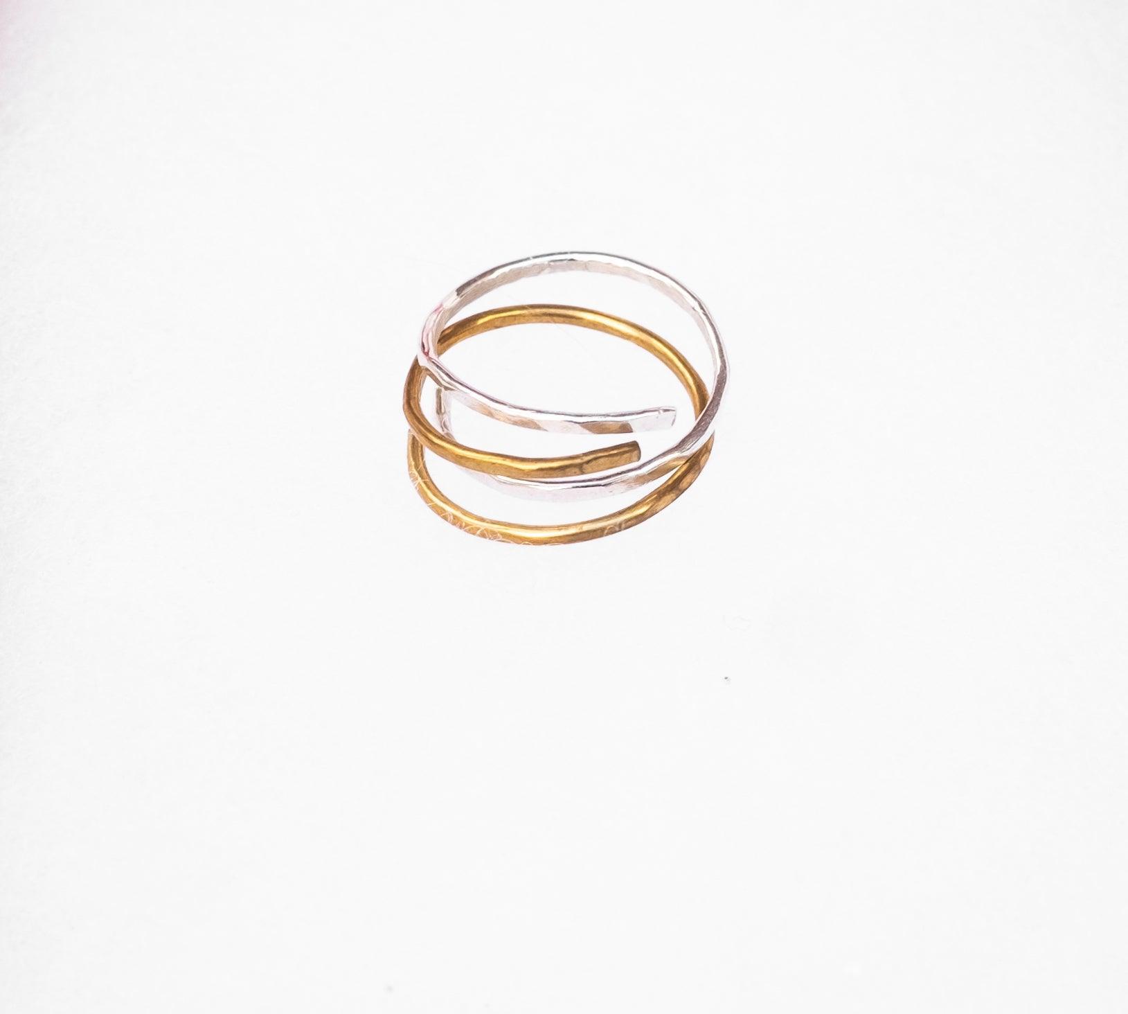 Hand-Hammered Sterling Silver and Brass Wrap Rings stacked together for a mixed metal look.