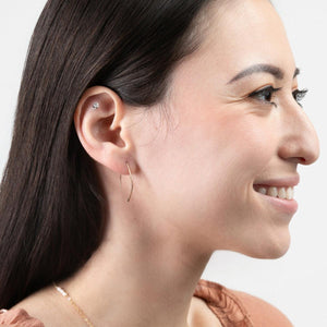 A woman wearing Qasioun Mini-Threader Earrings in 14k gold filled, which are small, lightweight earrings with a minimalist design.