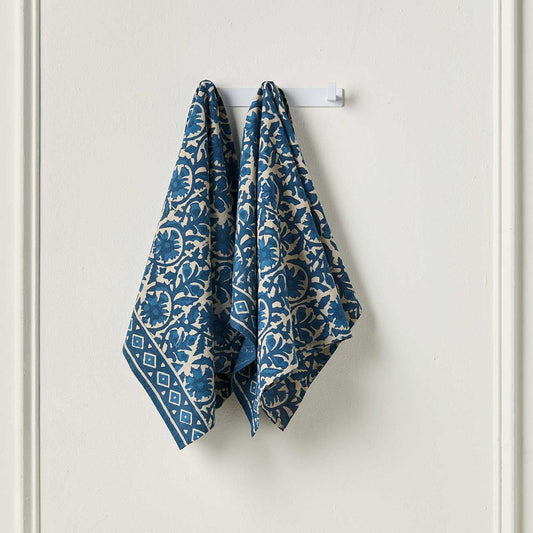 Two blue and white patterned towels on a white background
