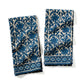 Two blue and white patterned towels on a white background