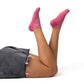 Person wearing pink ankle socks and a denim skirt on a white background