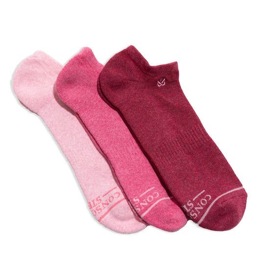 Box of pink and red socks with a 'conscious Step' packaging on a white background