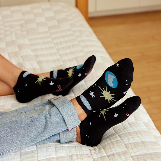 Black ankle sock with space-themed design on a white background