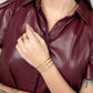 A woman in a red leather shirt showcasing the Journey of Hope Brass Bangle on her wrist.