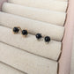 two pairs of stud earrings featuring black onyx beads; one pair is gold and the other is silver