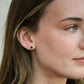 close up of model wearing a stud earring featuring a black onyx bead encircled in sterling silver