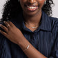 Woman in a navy pleated shirt wearing a Jordan Amazonite bracelet in sterling silver on her wrist,.