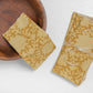 Block print yellow cotton napkins with floral patterns on a white surface