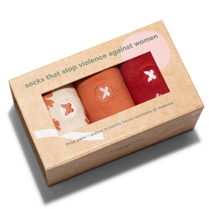 Box of three pairs of socks with a message about ending violence against women on a white background