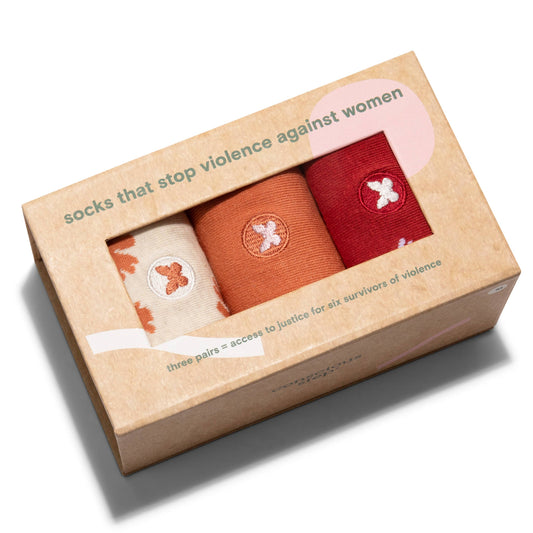 Box of three pairs of socks with a message about ending violence against women on a white background