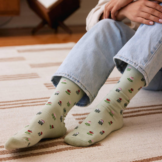 Light green crew socks with floral pattern on a white background