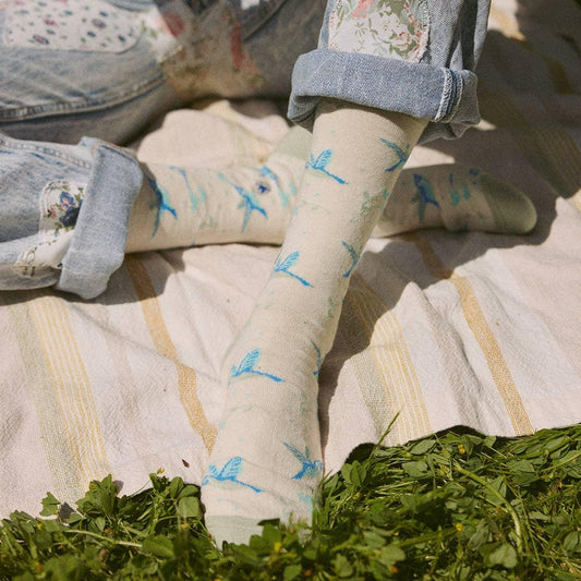 Cream-colored crew socks with hummingbirds on a white background