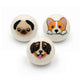 Three felted wool dryer balls with different dog faces on a white background