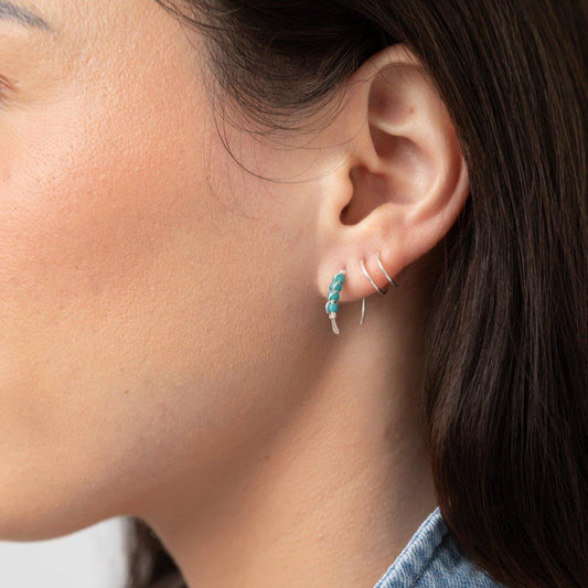 A close-up image of a woman's ear wearing Moab Western Beaded Threader Earrings in sterling silver. Hoop earring with turquoise beads.