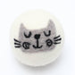 a reusable wool dryer ball with a cute gray cat face design on a white background