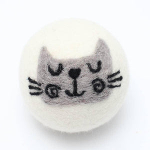 a reusable wool dryer ball with a cute gray cat face design on a white background