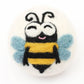 felted eco wool dryer ball with happy bee desigjn on a white background