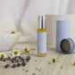 Skincare product labeled 'Calm' on a wooden surface with flowers and a bowl.