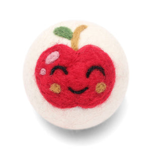 Felted apple-shaped wool dryer ball with a smiling face on a white background