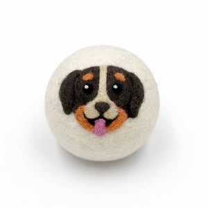felted wool dryer ball with a dog face design on a white background