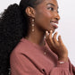 Woman wearing a pink sweater wearing freshwater pearl triple drop leverback earrings, necklace, and bracelet in 14k gold filled on a white background