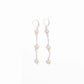 Pair of elegant freshwater pearl triple drop leverback earrings in sterling silver on a white background